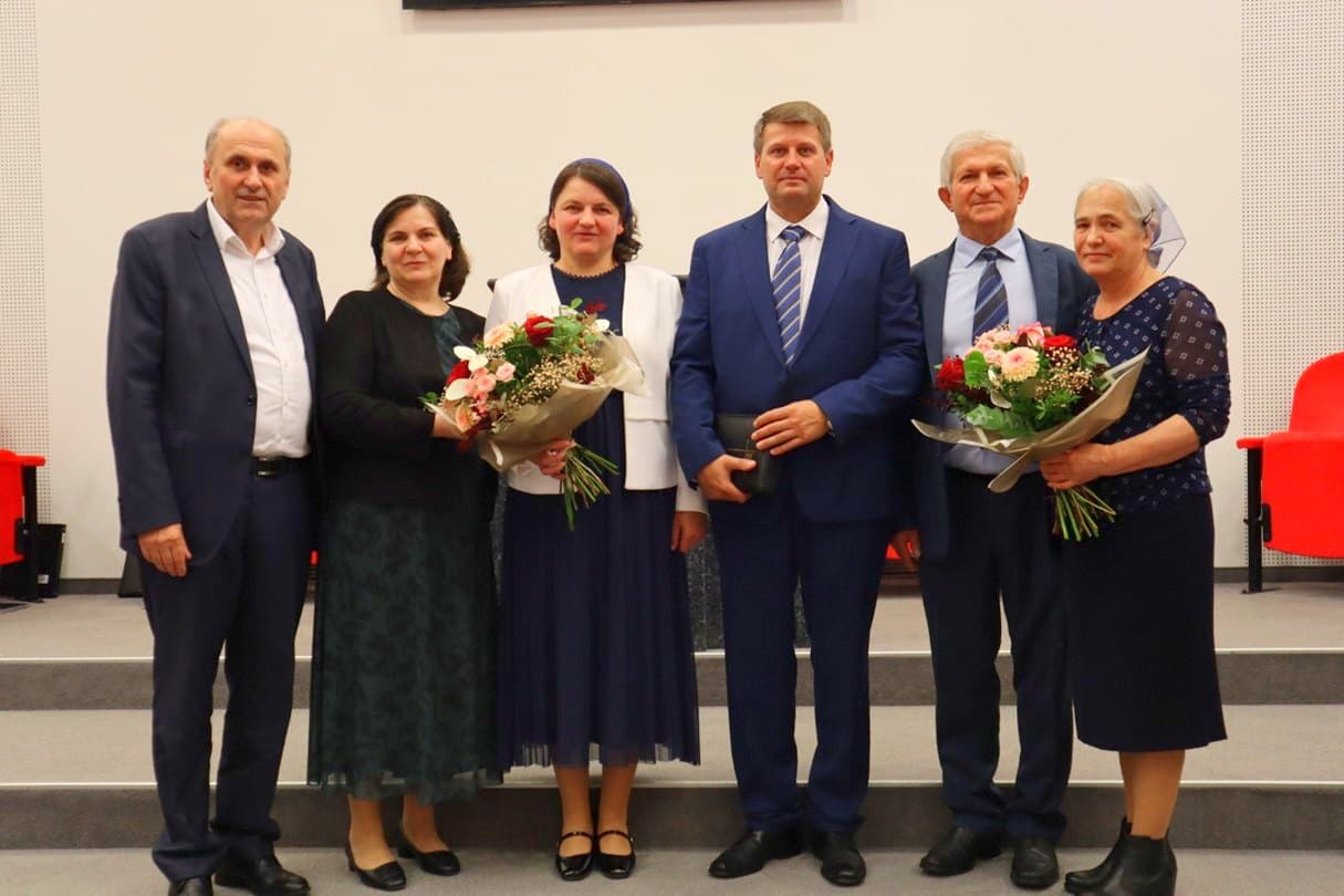De la stânga: familia Cotuțiu (fratele Pavel Cotuțiu, fostul prezbiter responsabil), familia Retegan (fratele Daniel Retegan, noul pastor coordonator) și familia Chira (fratele Traian Chira, fostul pastor coordonator), la slujba din 9 noiembrie 2025.
